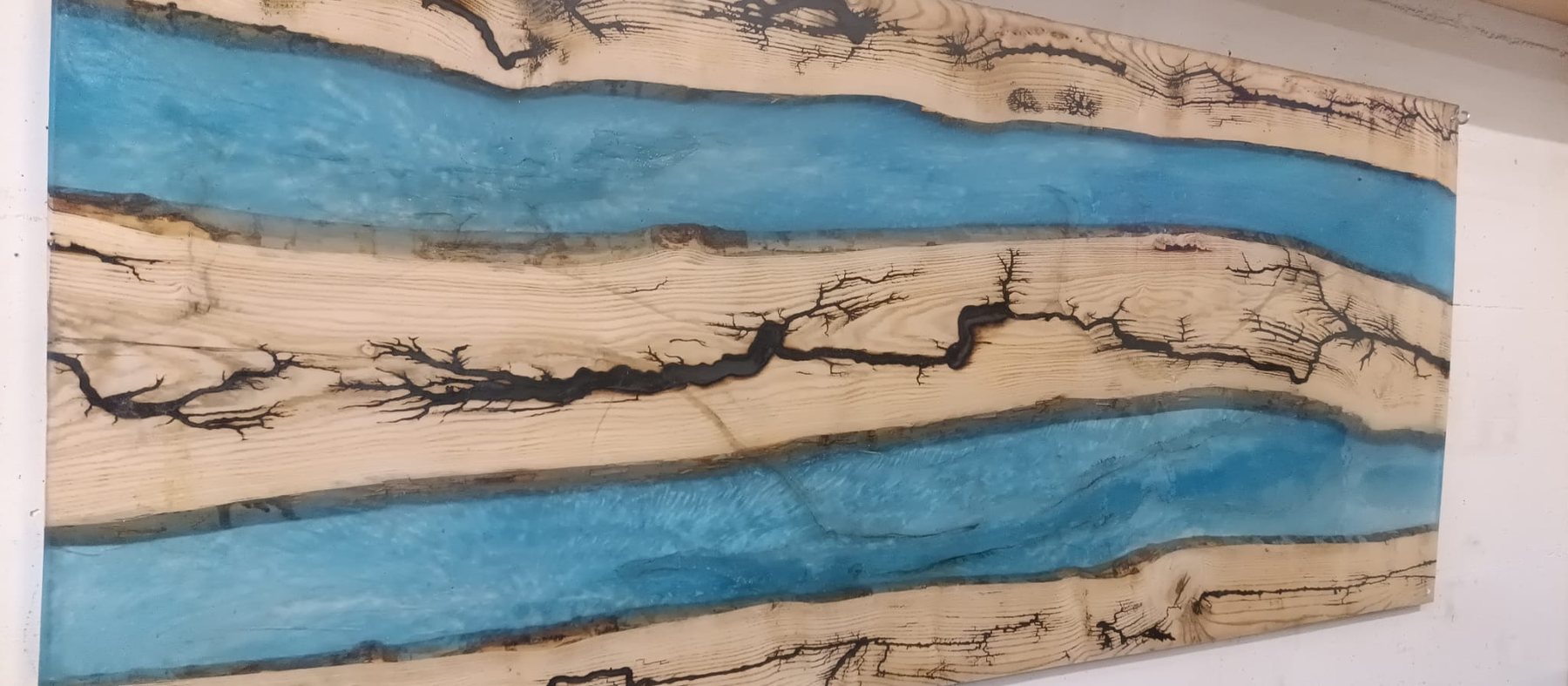Holzplatte mit Lichtenbergfiguren und zwei Flüssen aus blauem Epoxidharz