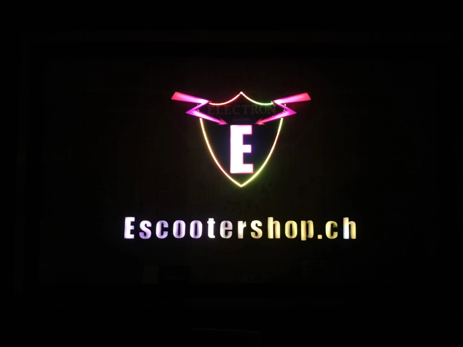 Beleuchtetes Logo mit Schild, Blitzen und dem Schriftzug Escootershop.ch